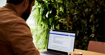 A man sitting at a table with a laptop, working on international SEO strategies.