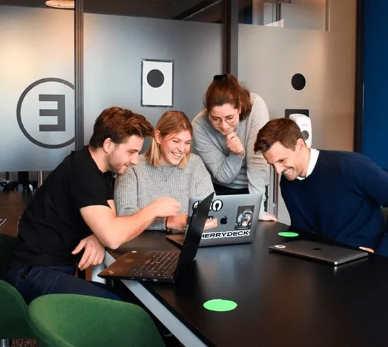 An international team of people collaborating at a table with laptops, focusing on SEO strategies.