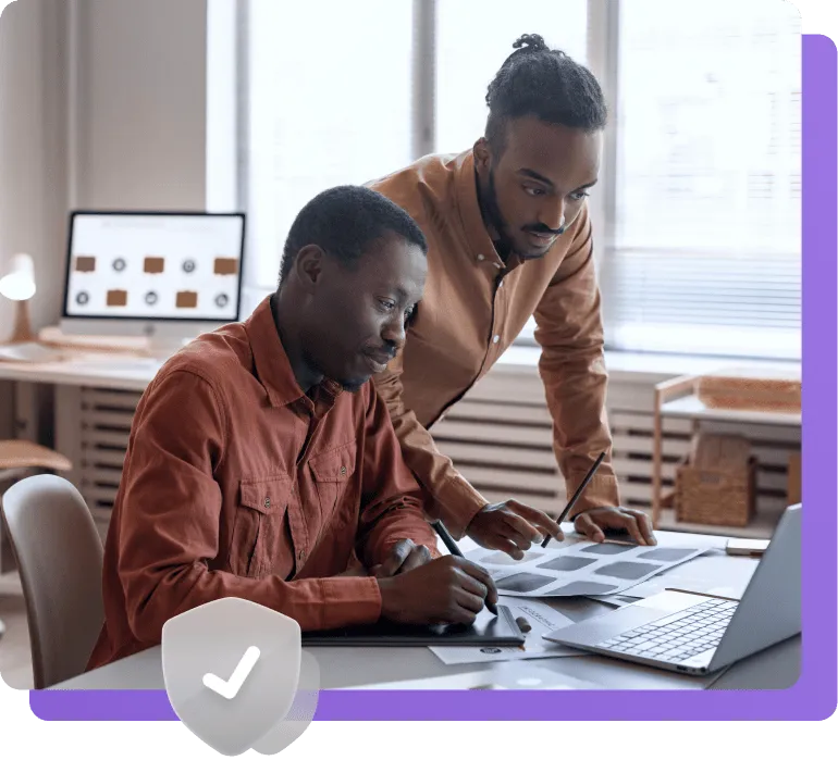 Two team members reviewing design mockups together on a laptop