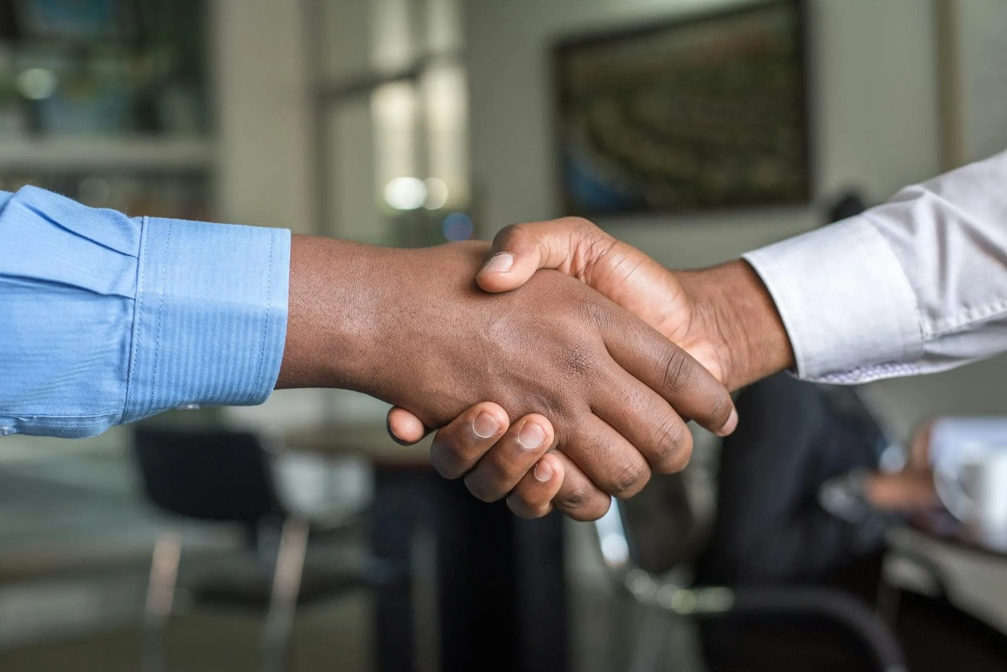 Close-up of two professionals shaking hands in a business setting