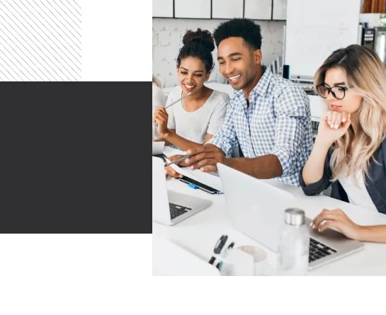 Diverse team of young professionals collaborating at a modern office using laptops